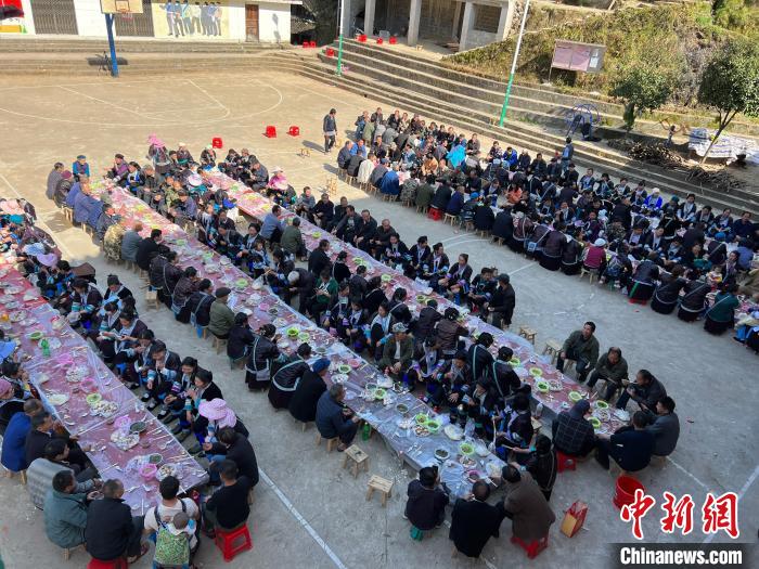 苗族男女同胞在村中品尝百家宴庆祝节日。　梁强 摄