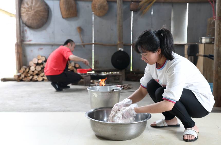 一名妇女在和面。三江侗族自治县融媒体中心供图