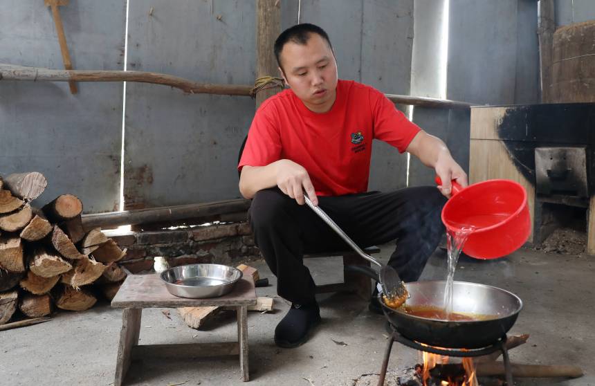 一名村民在煮糖水。三江侗族自治县融媒体中心供图