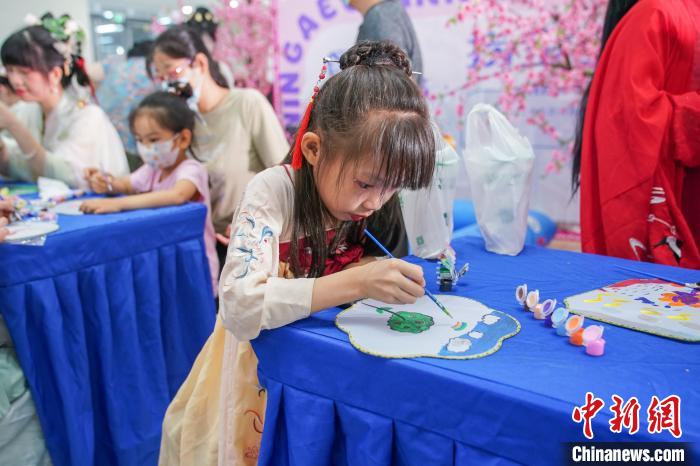 图为儿童身着汉服学习画团扇。 陈冠言 摄 图为儿童身着汉服学习画团扇。 陈冠言 摄