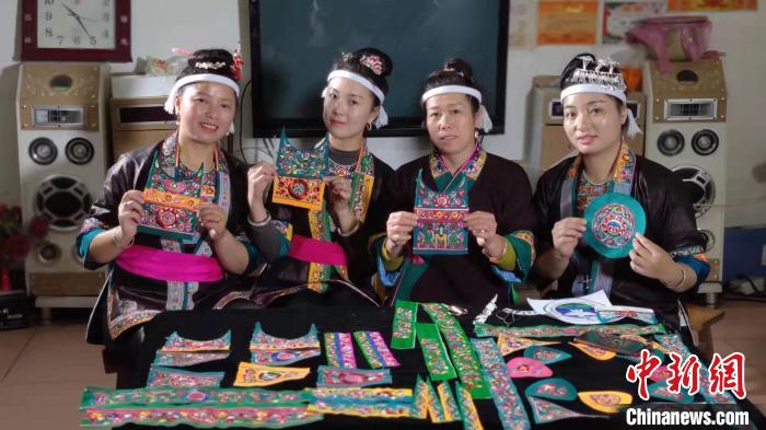 图为绣娘展示刺绣作品。　石玉岑 摄