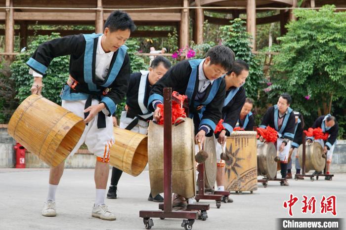 白裤瑶居民敲击铜鼓以两人为一组，一人敲鼓，另一人持风桶鼓荡。　韦国政 摄