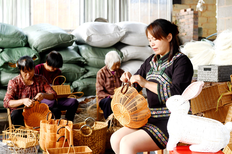 松山镇寻阳村的村民在编织工艺品