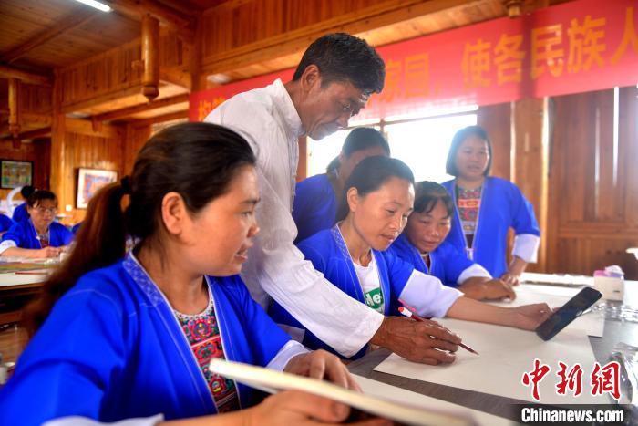 图为农民画老师指导学员构图。　滚亿忠 摄