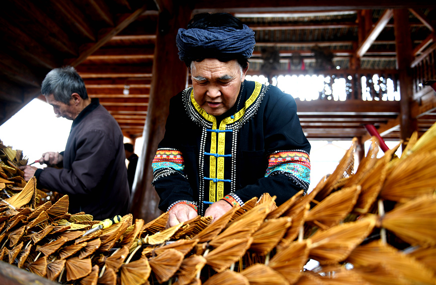 侗族村民将“龙鳞”安装在草龙身上 