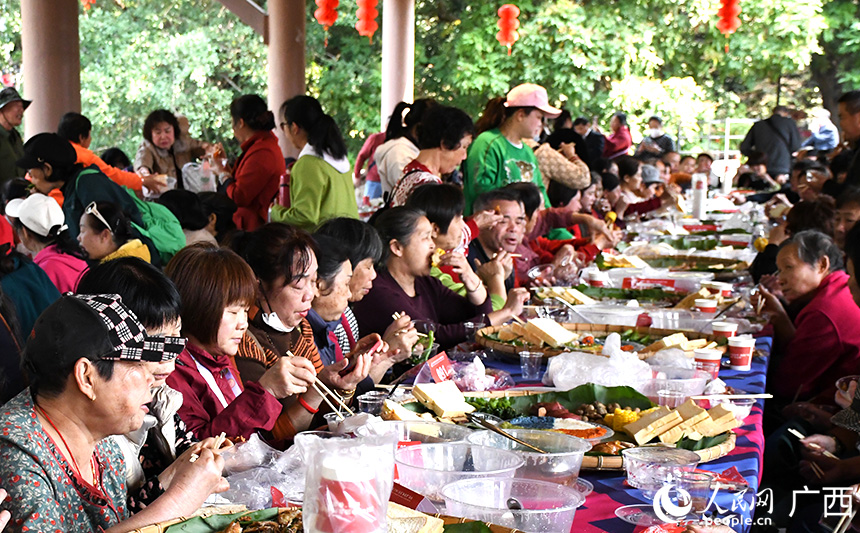 游客围坐长桌宴品鉴传统美食。人民网记者 覃心摄