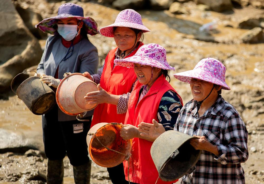 潭水里的群众正在敲桶助威。黄丽华摄
